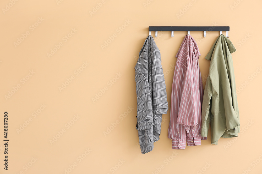 Hanger with clothes on color background