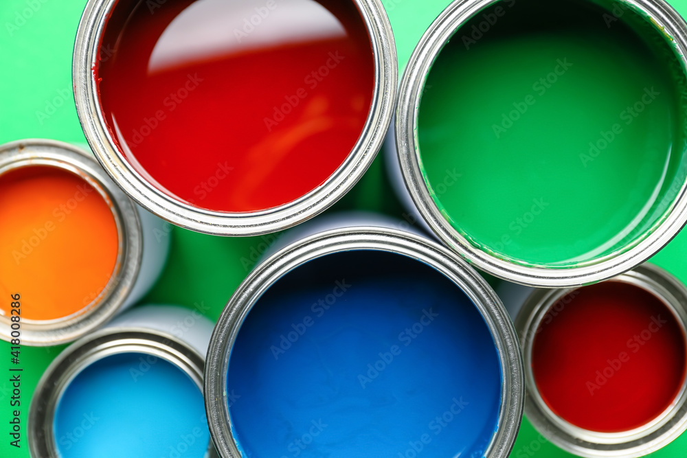 Cans of paints on color background