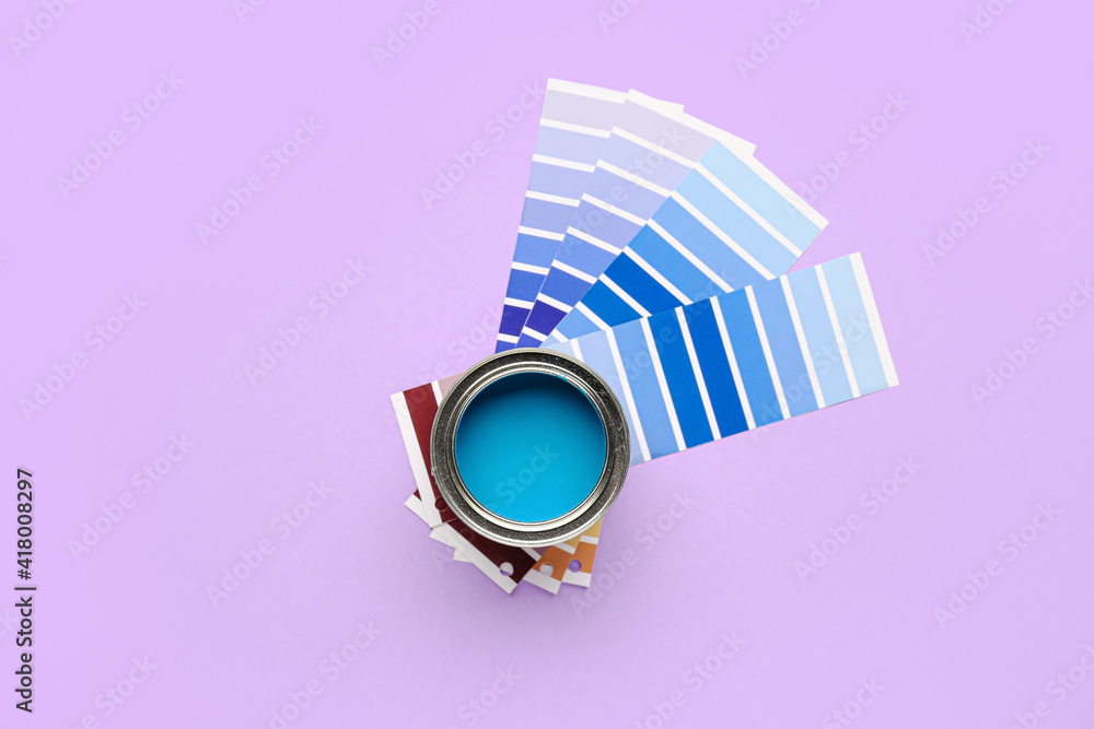 Can of blue paint with palette samples on color background