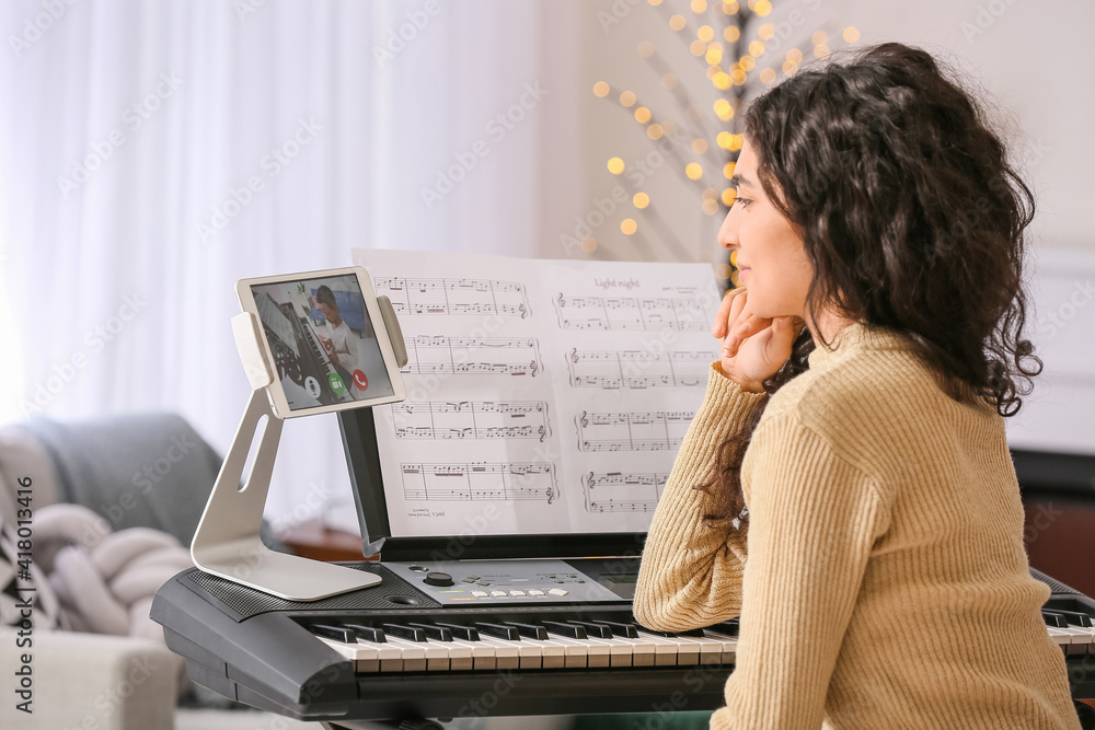 Young woman giving music lessons online at home