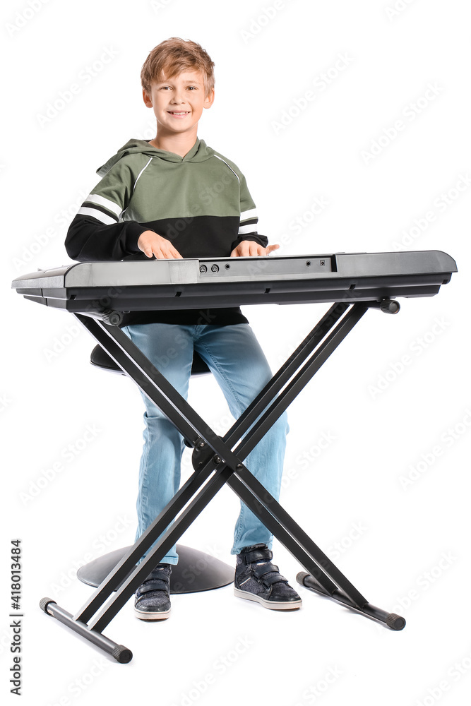 Little boy playing synthesizer on white background