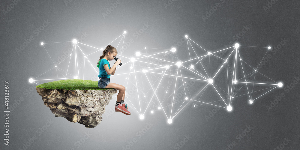 Concept of careless happy childhood with girl looking in binoculars