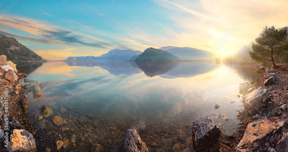 Sunset view from rocky shore of mountain lake