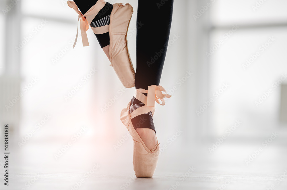 Closeup view on ballerina feet staying on tiptoes on one leg during ballet dance practice