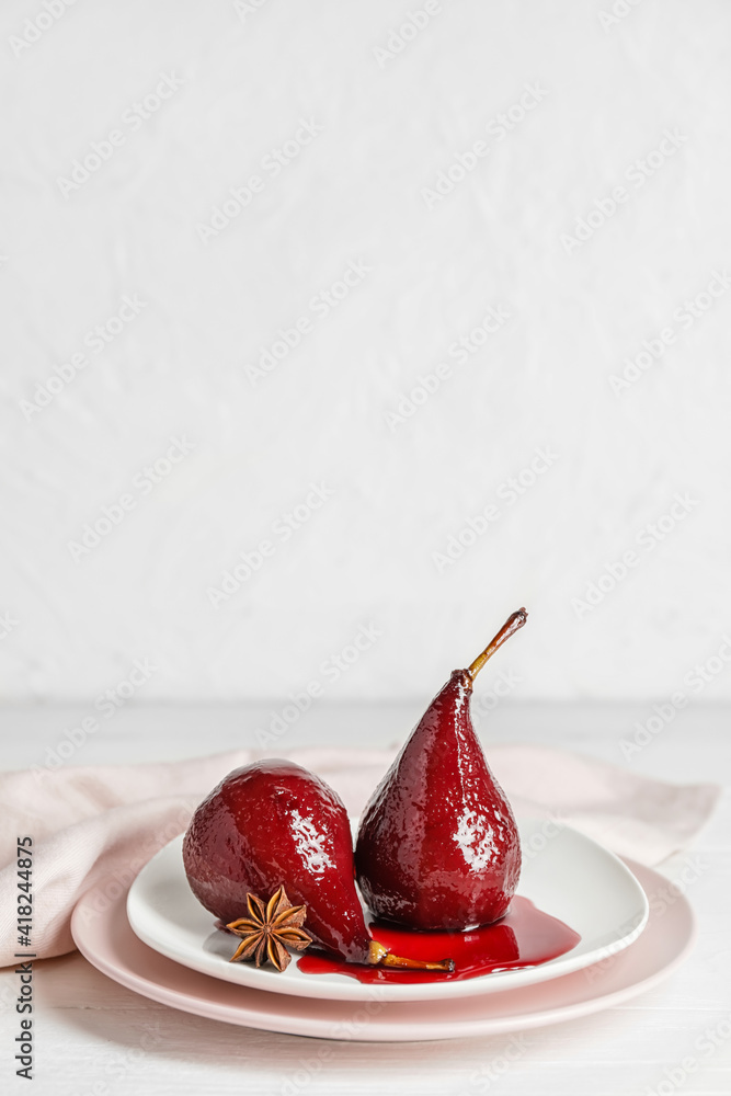 Plate with sweet poached pears in red wine on light background