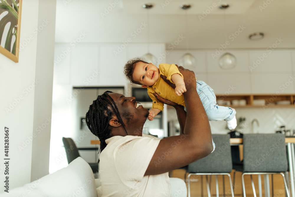 Portrait of an african american father playing with his baby girl.