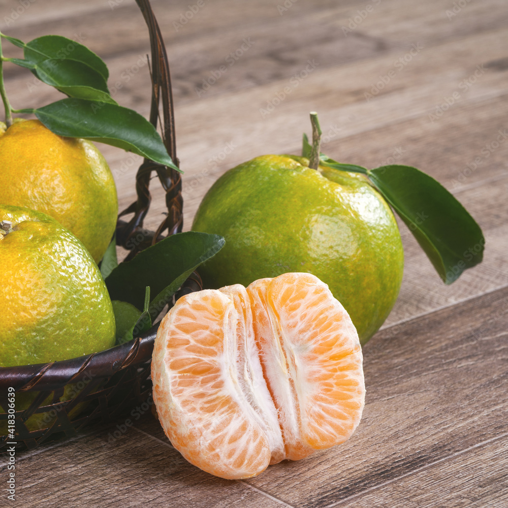 Fresh green tangerine mandarin orange on dark wooden table background.