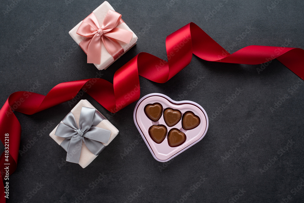 Beautiful gift box and chocolates on black background