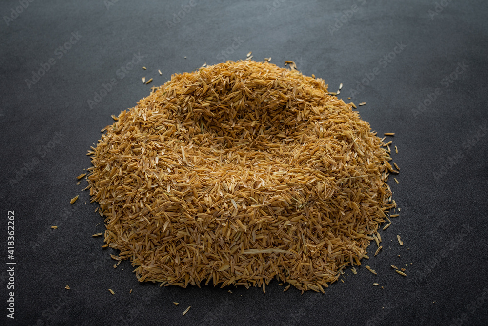 A pile of rice husks on a black background