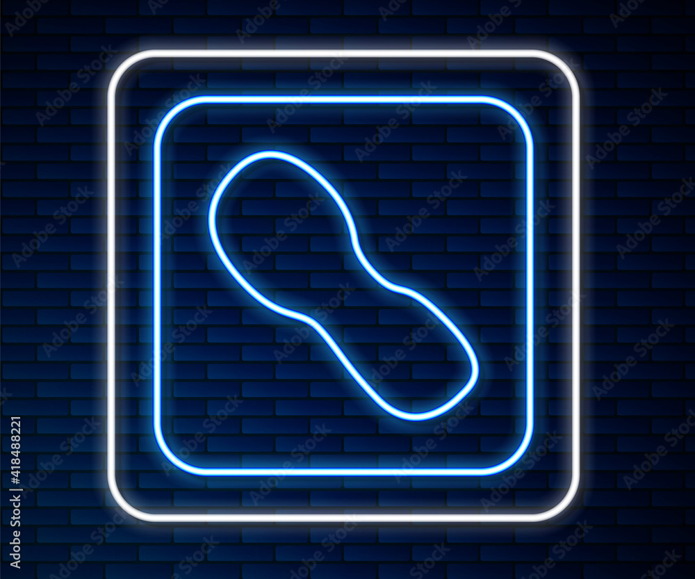 Glowing neon line Human footprints shoes icon isolated on brick wall background. Shoes sole. Vector.