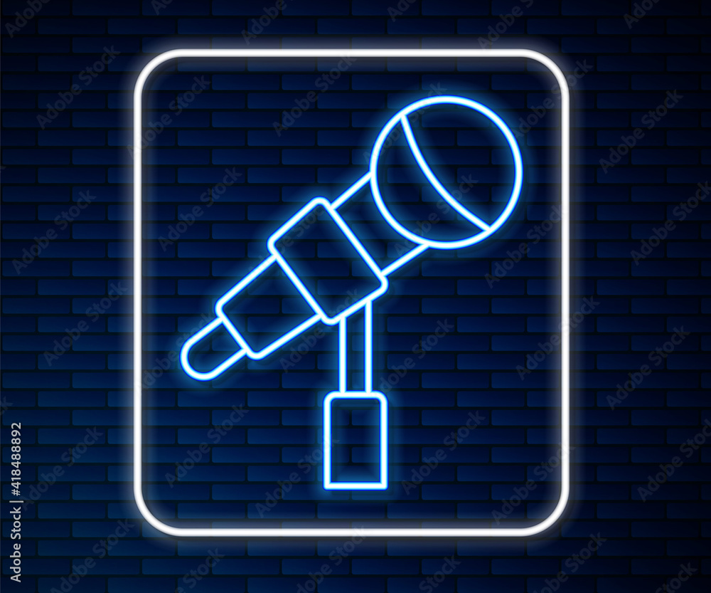 Glowing neon line Microphone icon isolated on brick wall background. On air radio mic microphone. Sp