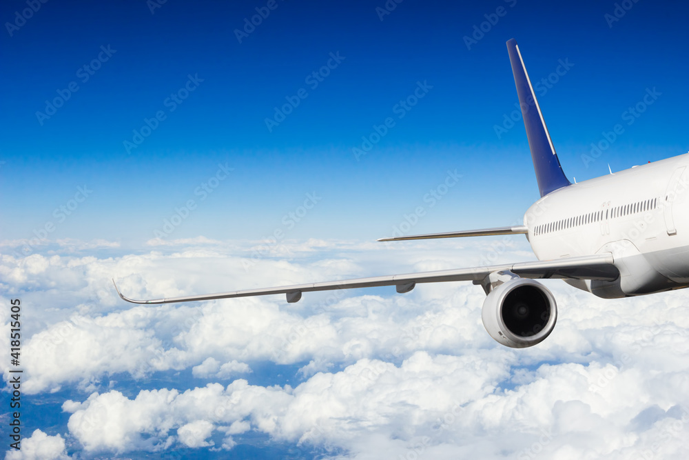 Detail of jetplane wing flying above clouds