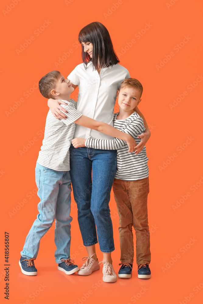 Happy mother and cute children on color background