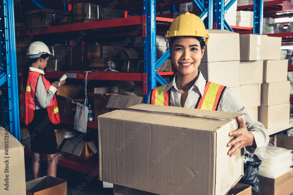 Portrait of young Asian woman warehouse worker smiling in the storehouse . Logistics , supply chain 