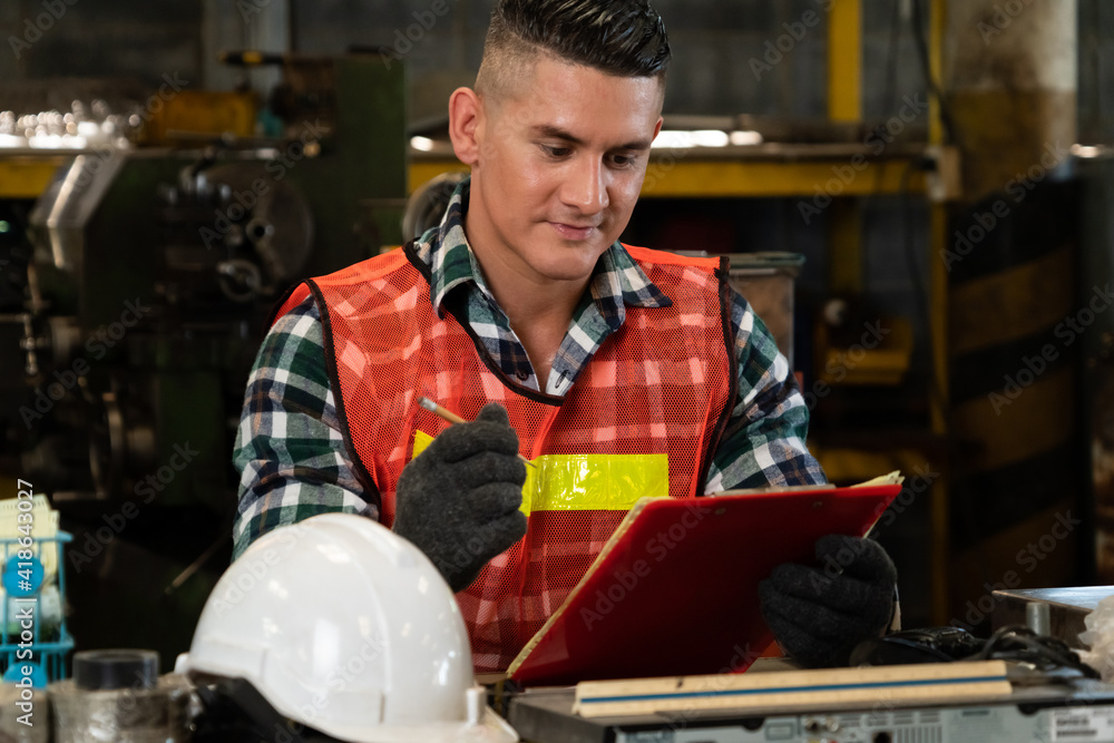 Manufacturing worker working with clipboard to do job procedure checklist . Factory production line 