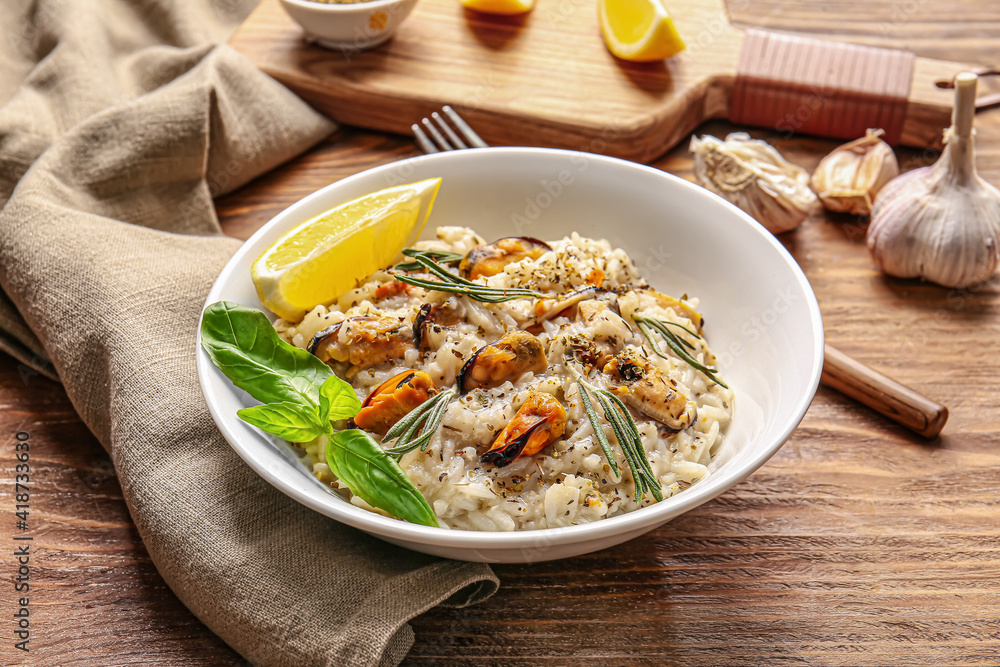 Plate with tasty risotto on wooden background