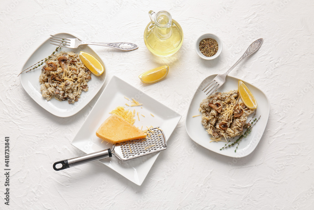 Plates with tasty risotto on light background