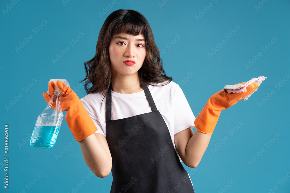 A photo of an Asian woman in an apron and gloves preparing for the cleaning job