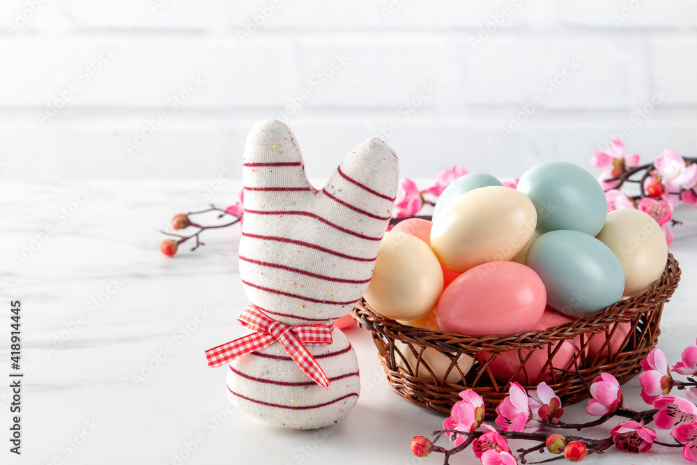 Close up of colorful Easter eggs in the nest with pink plum flower.