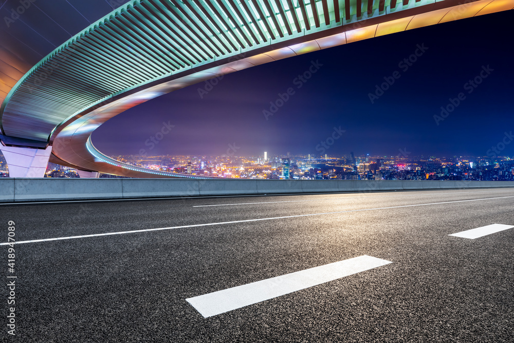 上海夜晚空旷的沥青路桥，城市天际线。