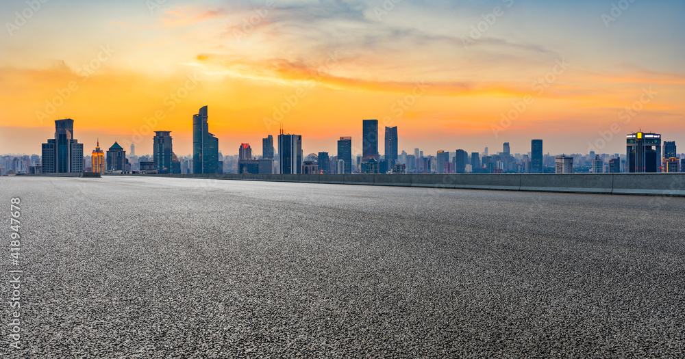 上海夕阳下空旷的柏油路和城市天际线。