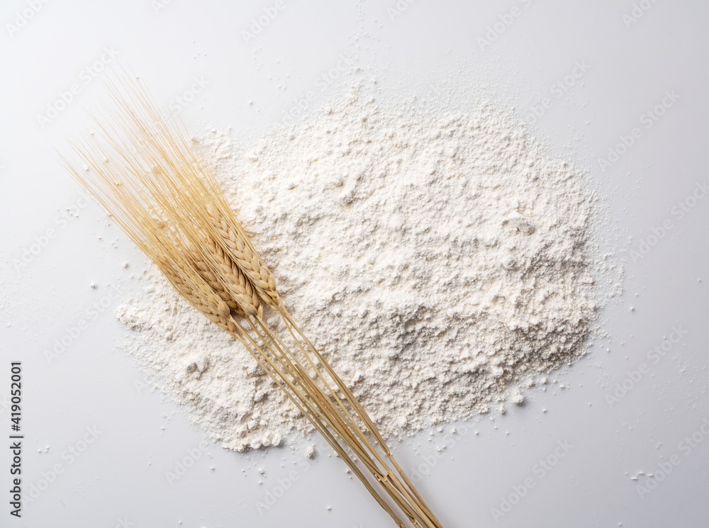 Flour and ears of wheat on a white background