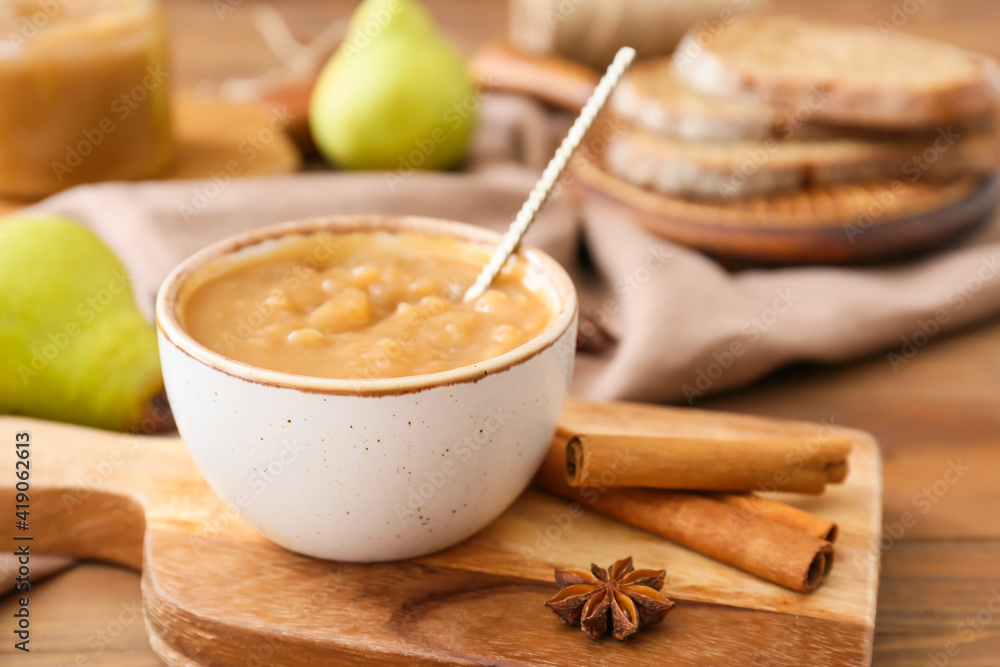 Bowl of tasty pear jam on wooden table