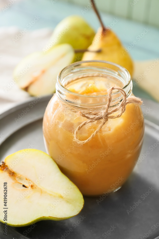 Jar of tasty pear jam on table, closeup