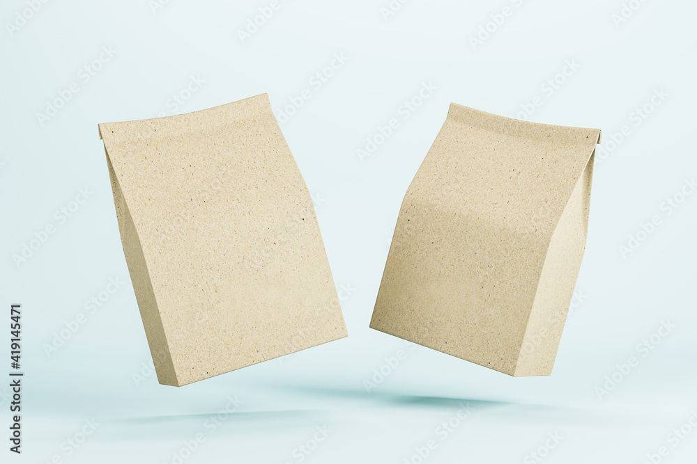 Two blank recycled kraft paper packages levitating in the air at light blue background. Mockup