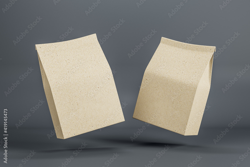 Two blank eco style kraft paper bags in the air on dark background. Mock up