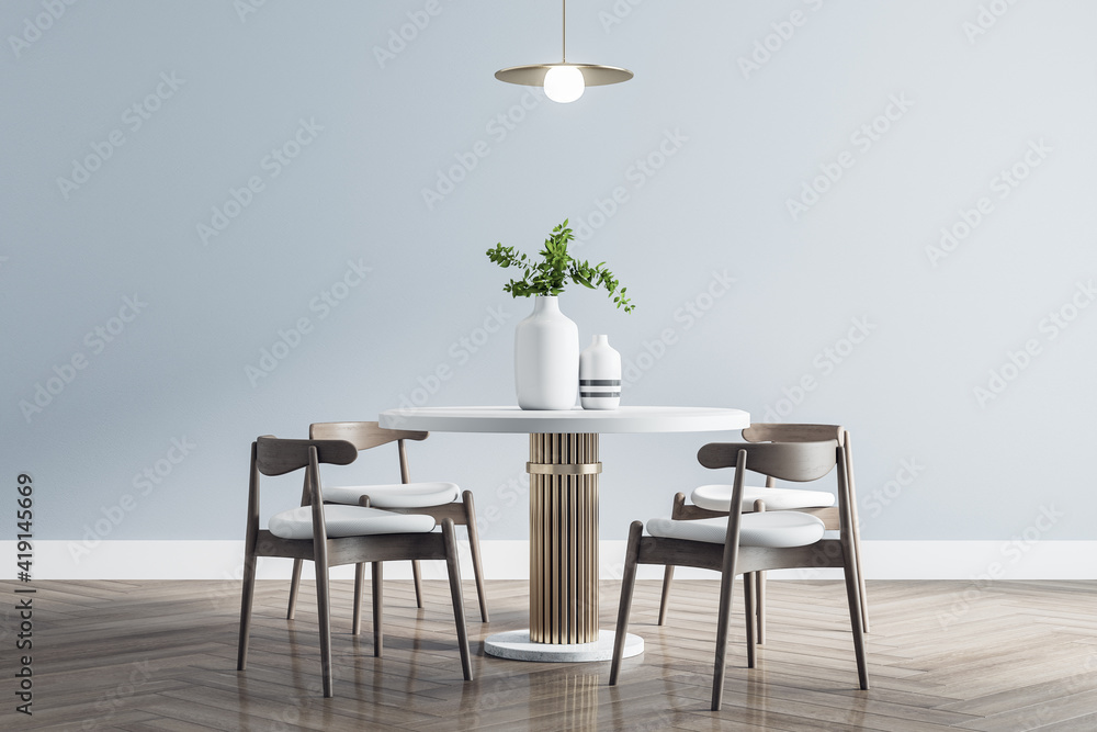 Modern white round dining table with wooden chairs around in stylish room with parquet and light wal