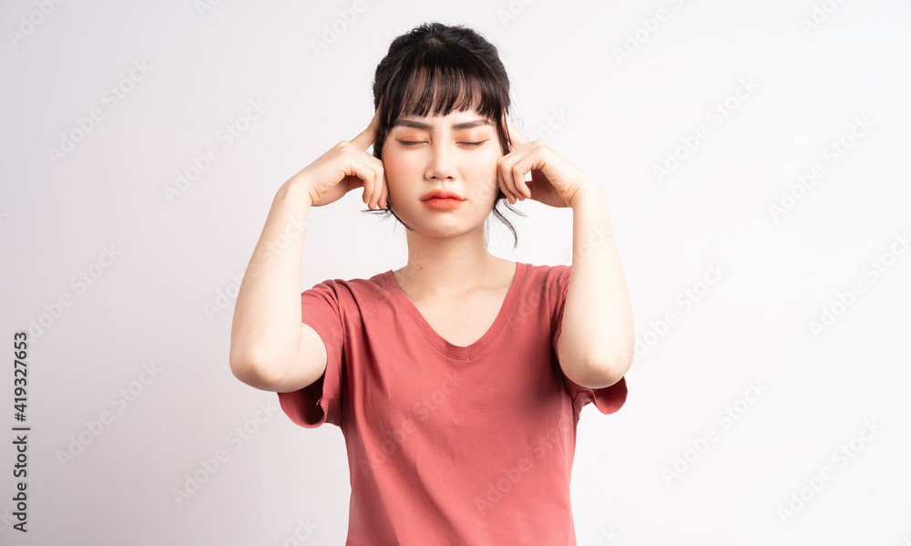 那个年轻的亚洲女孩愤怒地用手捂住耳朵