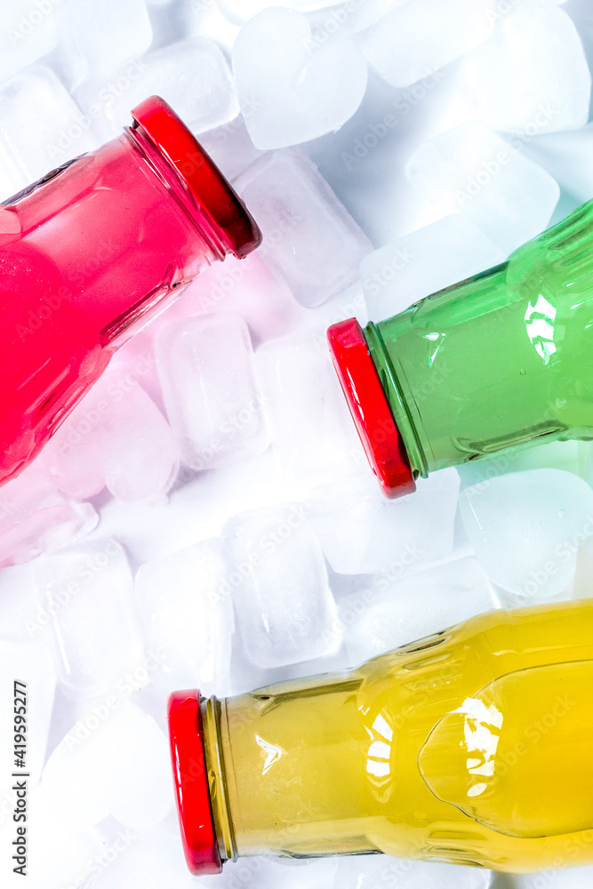 fruit drinks in colorful plastic bottles with ice top view mock-up