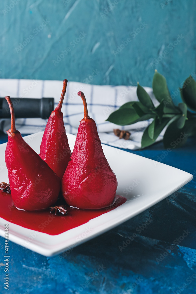 Plate of tasty poached pears in wine sauce on color background