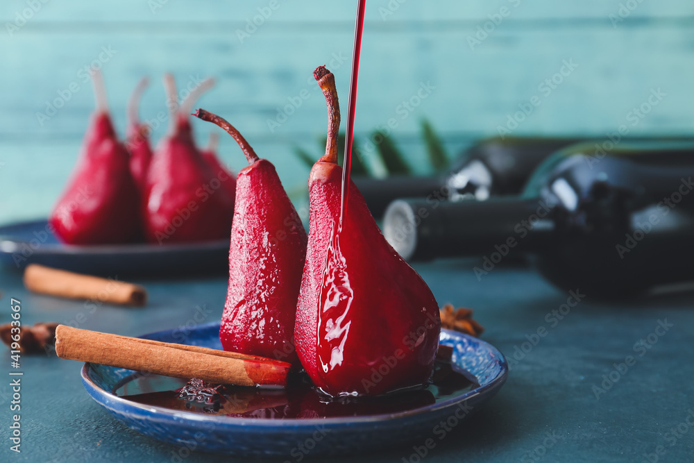 Plate of tasty poached pears in wine sauce on color background