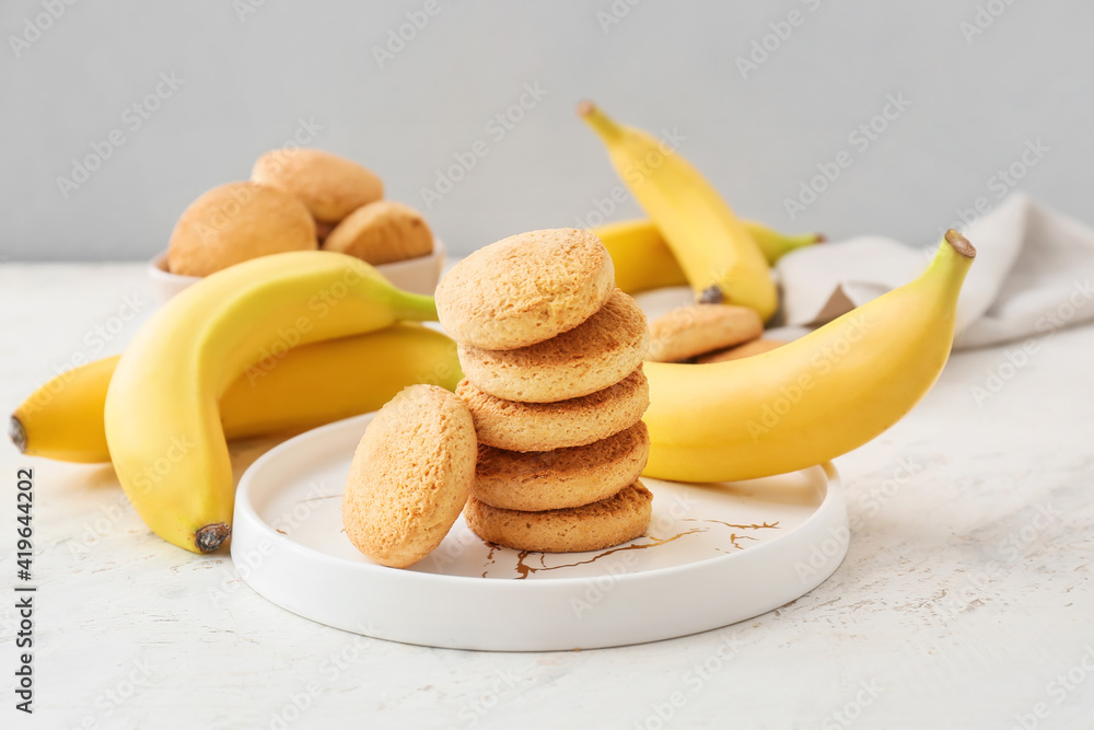 清淡背景下有美味的饼干和香蕉的盘子