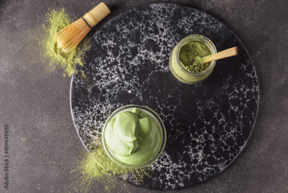 Composition with tasty dalgona matcha latte on dark background