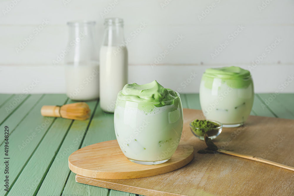 Composition with tasty dalgona matcha latte on color wooden background