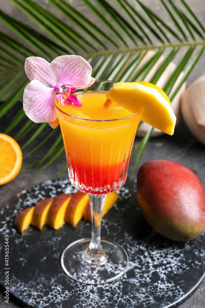 Glass of tasty mango margarita on dark background