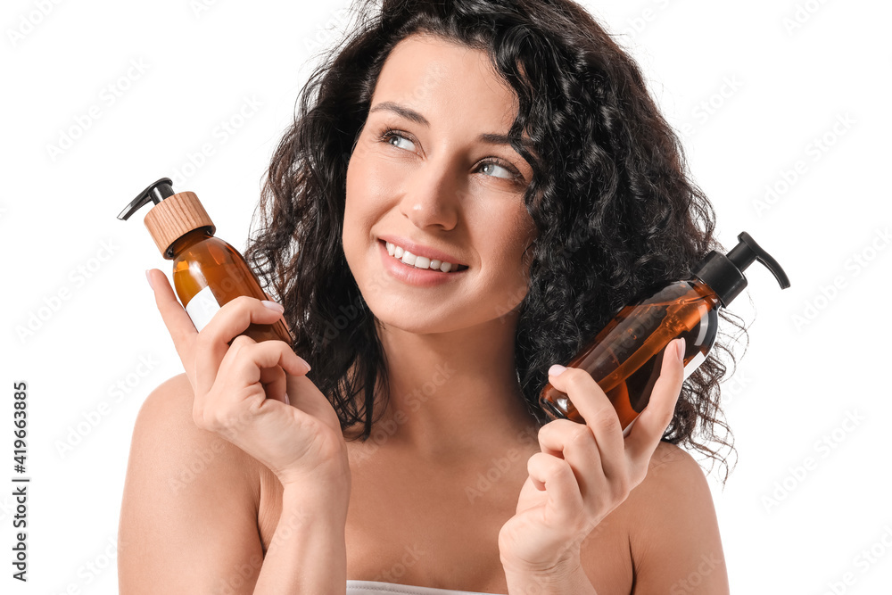 Beautiful young woman with cosmetic products on white background