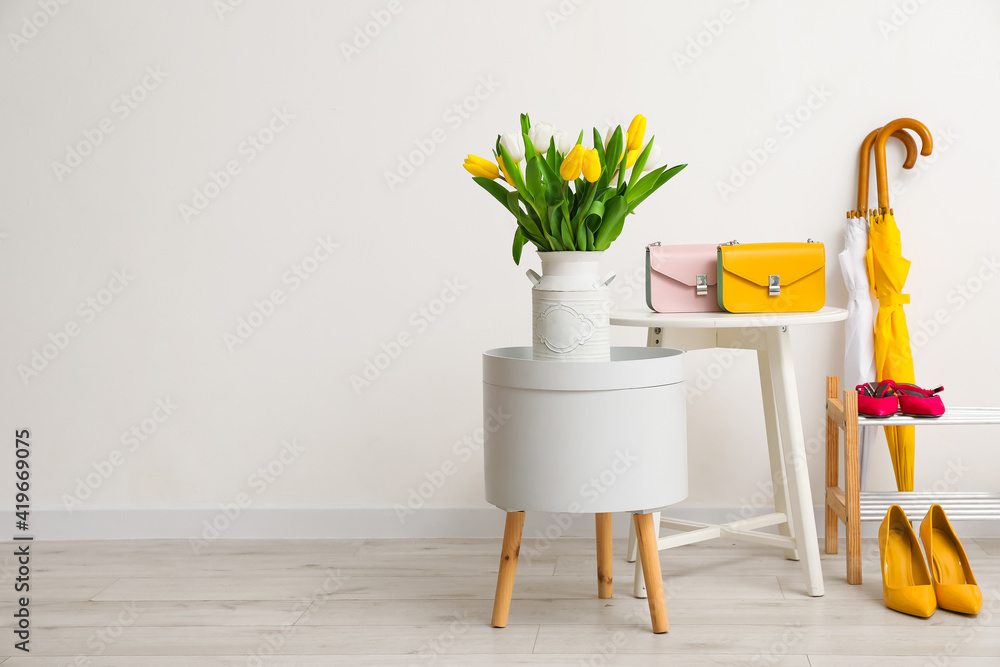 Bouquet of beautiful tulip flowers and stylish accessories in modern hallway