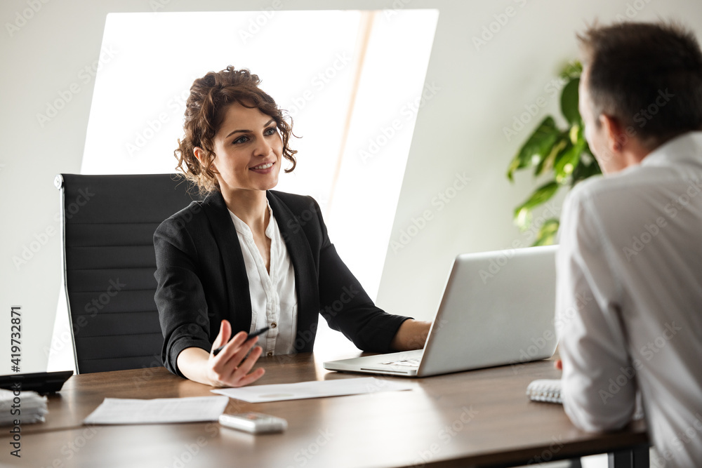 Smiling consultant talking to a client on a business meeting, portrait.