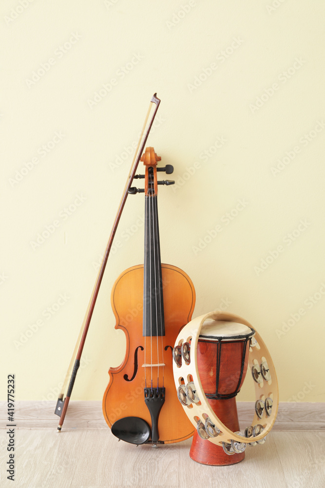 Different musical instruments near color wall