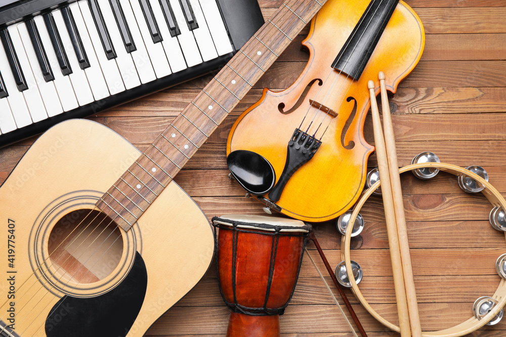 Different musical instruments on wooden background, closeup