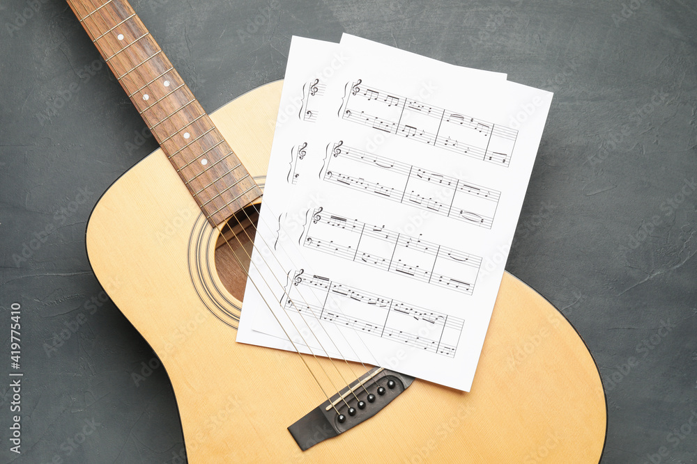 Acoustic guitar and music notes on dark background