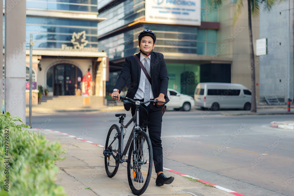 Asian businessman pushing his bicycle from home in the morning preparing to ride his bicycle to work