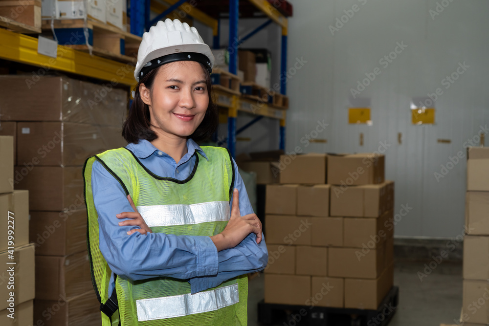 年轻的亚洲女仓库工人在仓库里微笑的肖像。物流，供应链