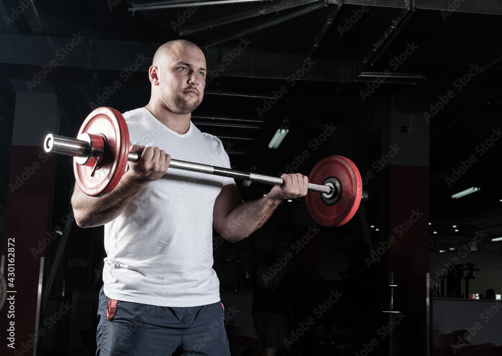 Male athlete lifts the barbell