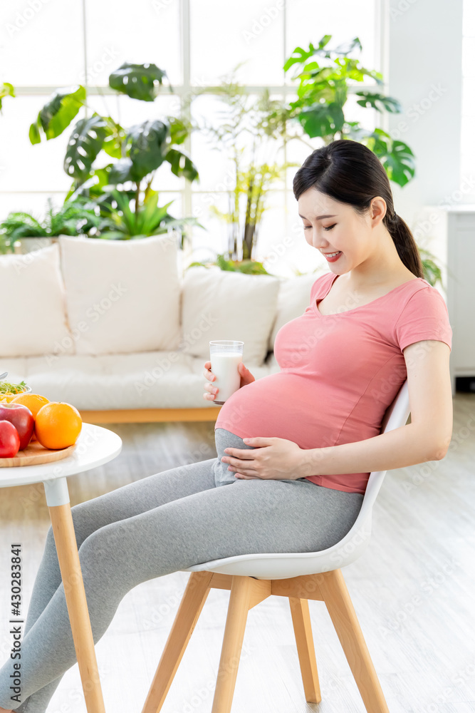 Asian pregnant woman drinking milk