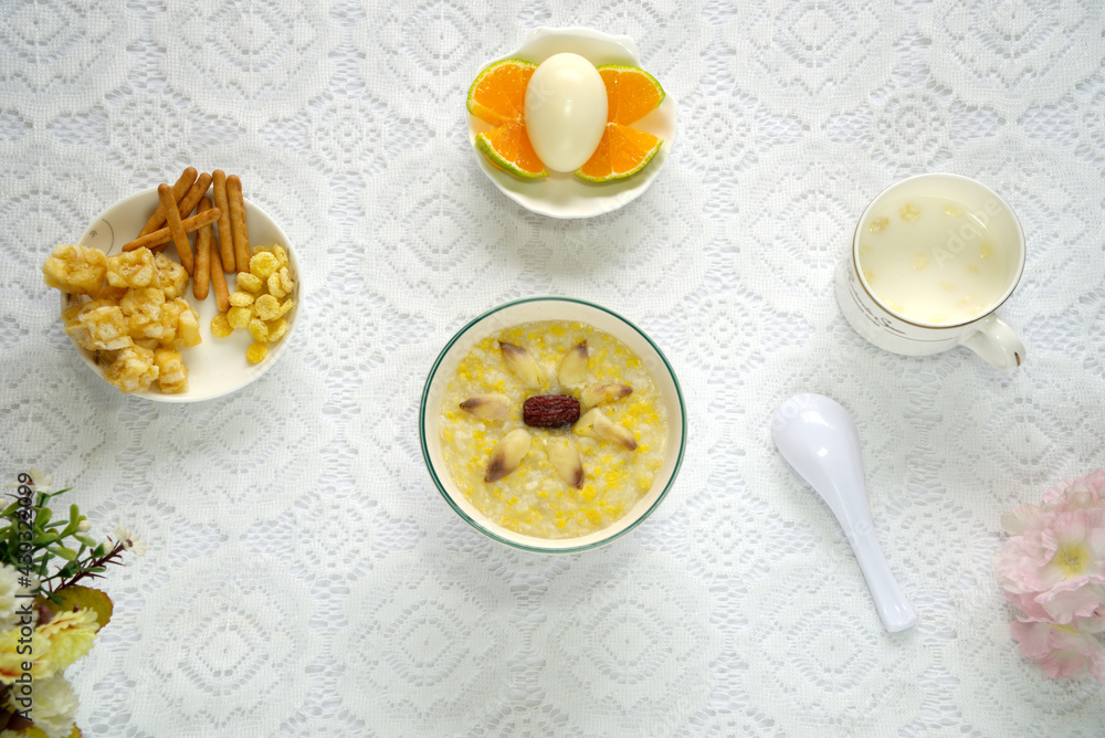 Red date rice porridge, eggs, oranges, shaqima and milk, healthy and nutritious breakfast, top view